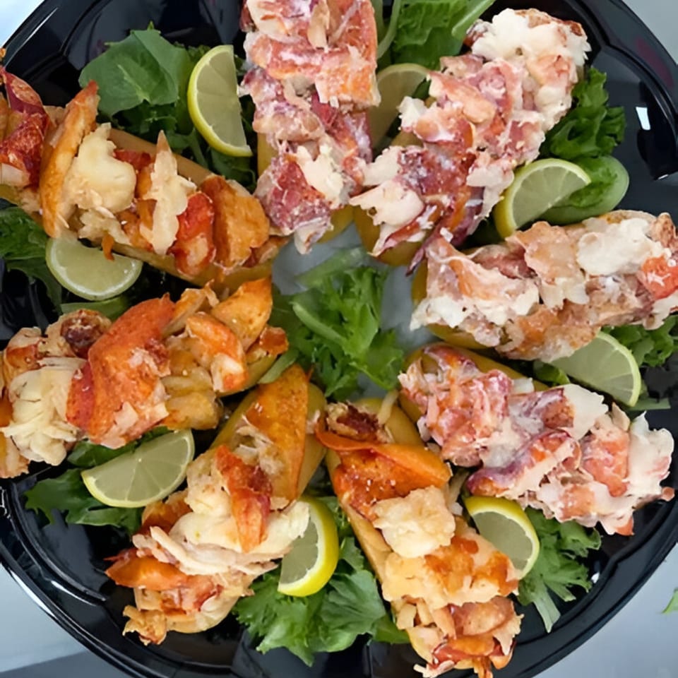 A platter of Mystic Lobster Roll Co.'s lobster rolls, garnished with lettuce and lime wedges.