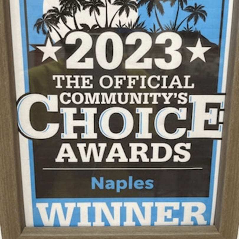 Framed 2023 Community's Choice Awards Winner sign for Naples, with palm trees.