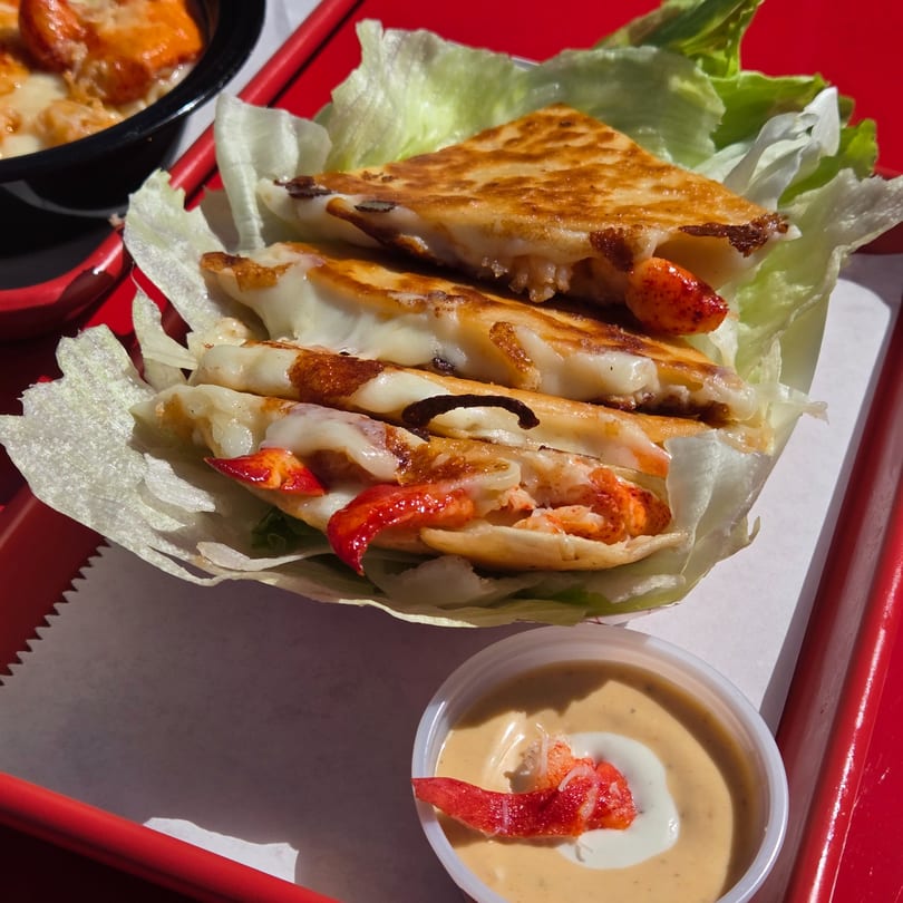 Mystic Lobster Roll Co's lobster quesadilla with melted cheese and a side of dipping sauce.